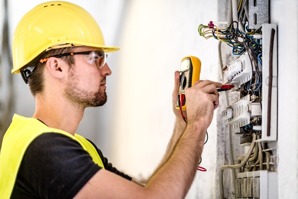 An electrician repairing circuit breakers which represents the blog "electrical safety nsw".
